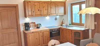 a kitchen with wooden cabinets and a sink and a stove at Urlaub auf dem Bergbauernhof Gigglhirn in Ulten in Ultimo
