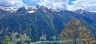 a mountain with a lake and snow capped mountains at Urlaub auf dem Bergbauernhof Gigglhirn in Ulten in Ultimo