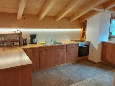 a large kitchen with wooden cabinets and a sink at Urlaub auf dem Bergbauernhof Gigglhirn in Ulten in Ultimo