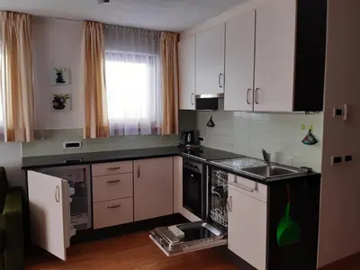 a small kitchen with white cabinets and a sink at Raisc - La tua casa in Val Badia in La Villa