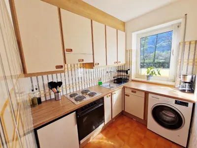 a kitchen with a washing machine and a window at Apartment Geranie - Alpstay in Naturno