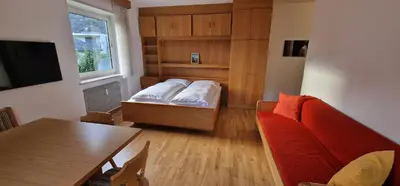 a living room with a couch and a table at Apartment Geranie - Alpstay in Naturno