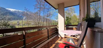 a balcony with a table and chairs and mountains at Apartment Geranie - Alpstay in Naturno