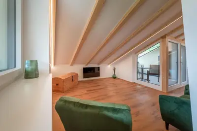 a living room with a green couch and a tv at Appartments DAS Hubertus in Termeno