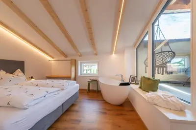 a bedroom with two beds and a bath tub at Appartments DAS Hubertus in Termeno