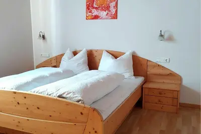 a wooden bed with two pillows on it in a room at RÖCK Weingut - winery in Villandro