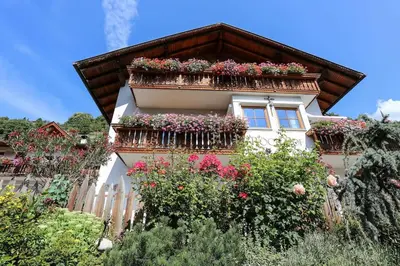a house with flower boxes on the balcony at RÖCK Weingut - winery in Villandro