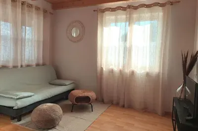 a bedroom with a bed and a ottoman and a window at RÖCK Weingut - winery in Villandro