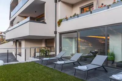 an apartment patio with chairs and a balcony at Charming Suite by Dornsberg Panoramic Apartments in Schenna