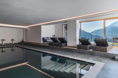 a house with a swimming pool with mountains in the background at Charming Suite by Dornsberg Panoramic Apartments in Schenna