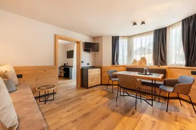 a living room with a table and chairs at Suite del Podesta' in Moena