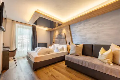 a living room with a couch and a bed at Suite del Podesta' in Moena