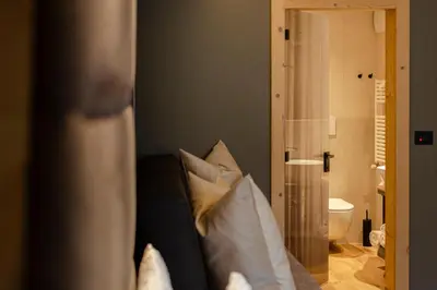 a room with a couch with pillows and a bathroom at Suite del Podesta' in Moena
