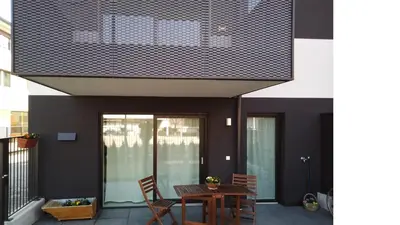 a patio with a table and chairs on a building at Al cantuccio di Chiara in Brunico