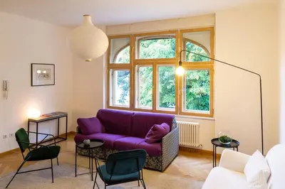 a living room with a purple couch and a window at Cityappartment Villa Landeck in Merano