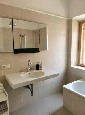 a white bathroom with a sink and a mirror at Cityappartment Villa Landeck in Merano