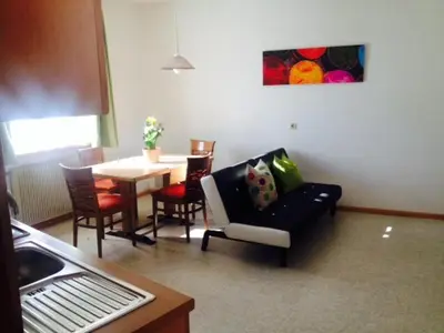 a living room with a couch and a table with chairs at B&B Zum Guten Tropfen in San Paolo