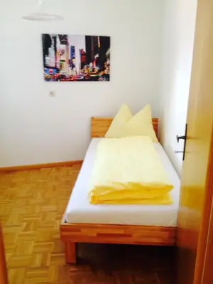 a bed in a room with a picture on the wall at B&B Zum Guten Tropfen in San Paolo