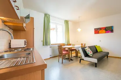 a kitchen and living room with a couch and a table at B&B Zum Guten Tropfen in San Paolo