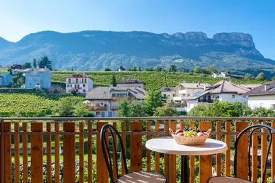 a table and chairs with a basket of fruit on a balcony at B&B Zum Guten Tropfen in San Paolo
