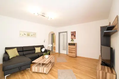 a living room with a black couch and a tv at B&B Zum Guten Tropfen in San Paolo