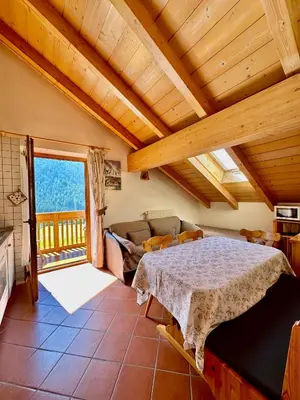 a bedroom with a bed and a couch and a window at Villa Rosa in Vigo di Fassa