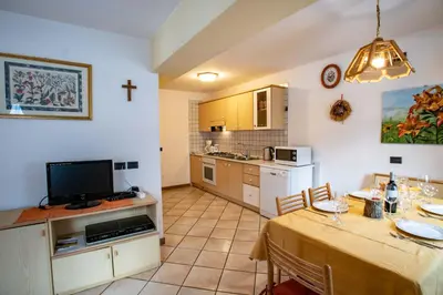 a kitchen and dining room with a table and a tv at Villa Rosa in Vigo di Fassa