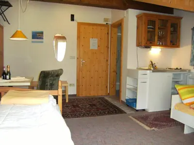 a bedroom with a bed and a kitchen and a door at Gassermühle-Ferienhaus in Eggen