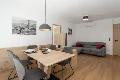a living room with a table and chairs and a couch at Justina 7 Apartments in San Paolo