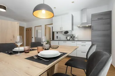 a kitchen with a wooden table with chairs and a dining room at Justina 7 Apartments in San Paolo