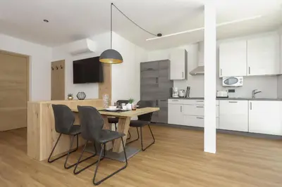a kitchen and dining room with a table and chairs at Justina 7 Apartments in San Paolo