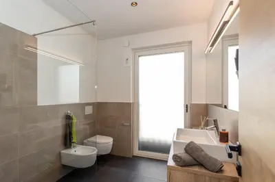 a bathroom with a sink and a toilet and a mirror at Justina 7 Apartments in San Paolo
