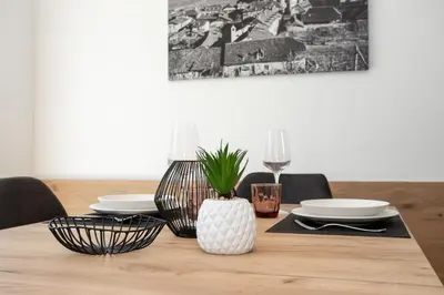 a wooden table with plates and a vase on it at Justina 7 Apartments in San Paolo