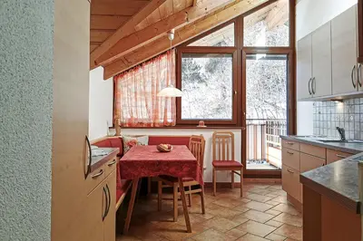 a kitchen with a table with a red table cloth at Moosbachhof - Ferienwohnung Marienkäfer in Collalbo