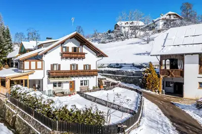 a house in the snow with a fence at Moosbachhof - Ferienwohnung Marienkäfer in Collalbo