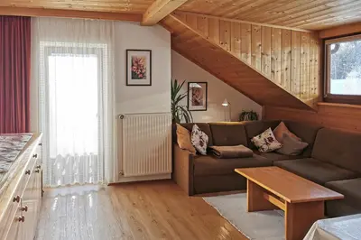 a living room with a couch and a table at Moosbachhof - Ferienwohnung Marienkäfer in Collalbo