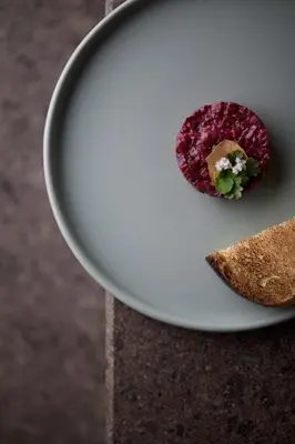 a white plate with a piece of food on it at fink Restaurant & Suites in Brixen