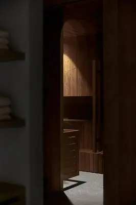 a wooden cabinet with a mirror in a room at fink Restaurant & Suites in Brixen