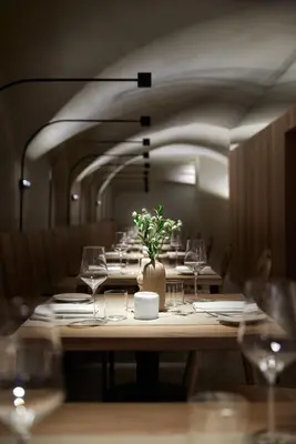 a table with glasses and a vase of flowers on it at fink Restaurant & Suites in Brixen