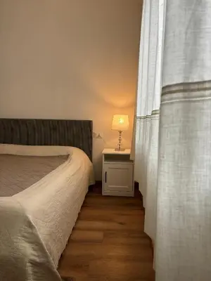 a bedroom with a bed and a table with a lamp at Casa Latemar in Moena
