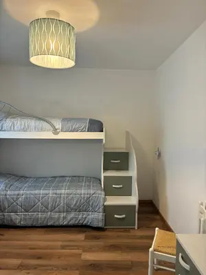 a bedroom with a bunk bed and a desk at Casa Latemar in Moena