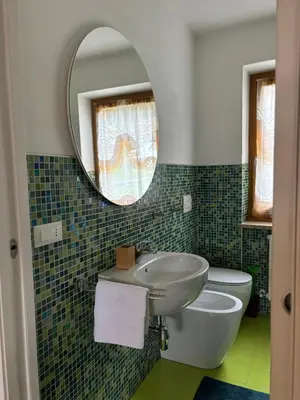 a bathroom with a sink and a toilet and a mirror at Casa Latemar in Moena