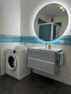 a bathroom with a washing machine and a sink at Casa Latemar in Moena