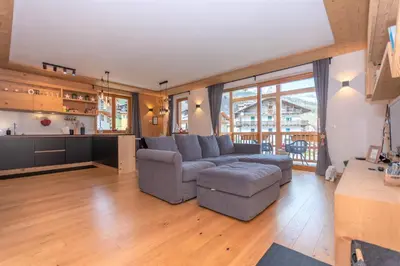 a living room with a couch and a kitchen at Casa Mari in Falcade