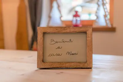 a picture frame with a handwritten sign on a table at Casa Mari in Falcade