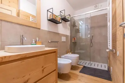 a bathroom with a toilet and a sink and a shower at Casa Mari in Falcade