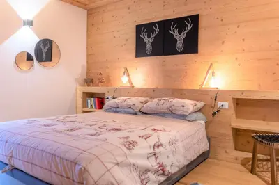 a bedroom with a bed in a wooden wall at Casa Mari in Falcade