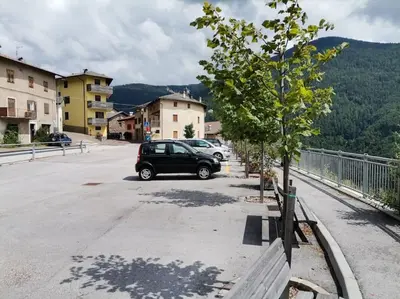 a car parked in a parking lot next to a tree at Verde di Valda in Valda