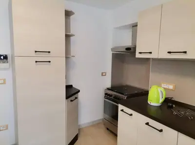 a kitchen with white cabinets and a black counter top at Verde di Valda in Valda