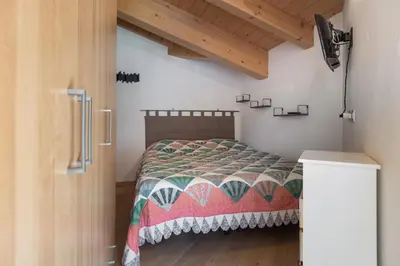 a bedroom with a bed with a quilt on it at DolomiApartments - Appartamento Coronelle in Predazzo